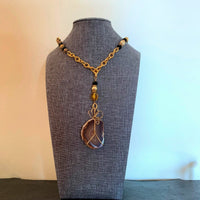 A necklace made of Banded Agate Geode with beaded chain