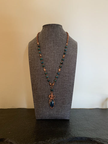 A necklace made of Oval Apatite stone with copper wrap on a rosary beaded necklace