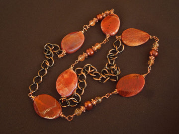 A necklace made of Fire Agate twisted ovals with copper pearls & crystals on copper chain