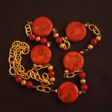 A necklace made of Large Coral Rounds with gold beads and red shell beads on gold chain