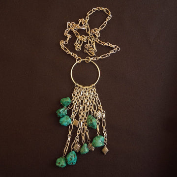 A necklace made of Turquoise Nuggets with silver accents hanging from silver chain on large silver ring
