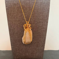 Pendant made of Beige Confusious with gold wire; 1.25" w x 2.25 h" incl bail