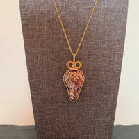 Pendant made of Leopard Skin Jasper triangular stone with gold wrap; 1" w x 2 3/8" H incl bail