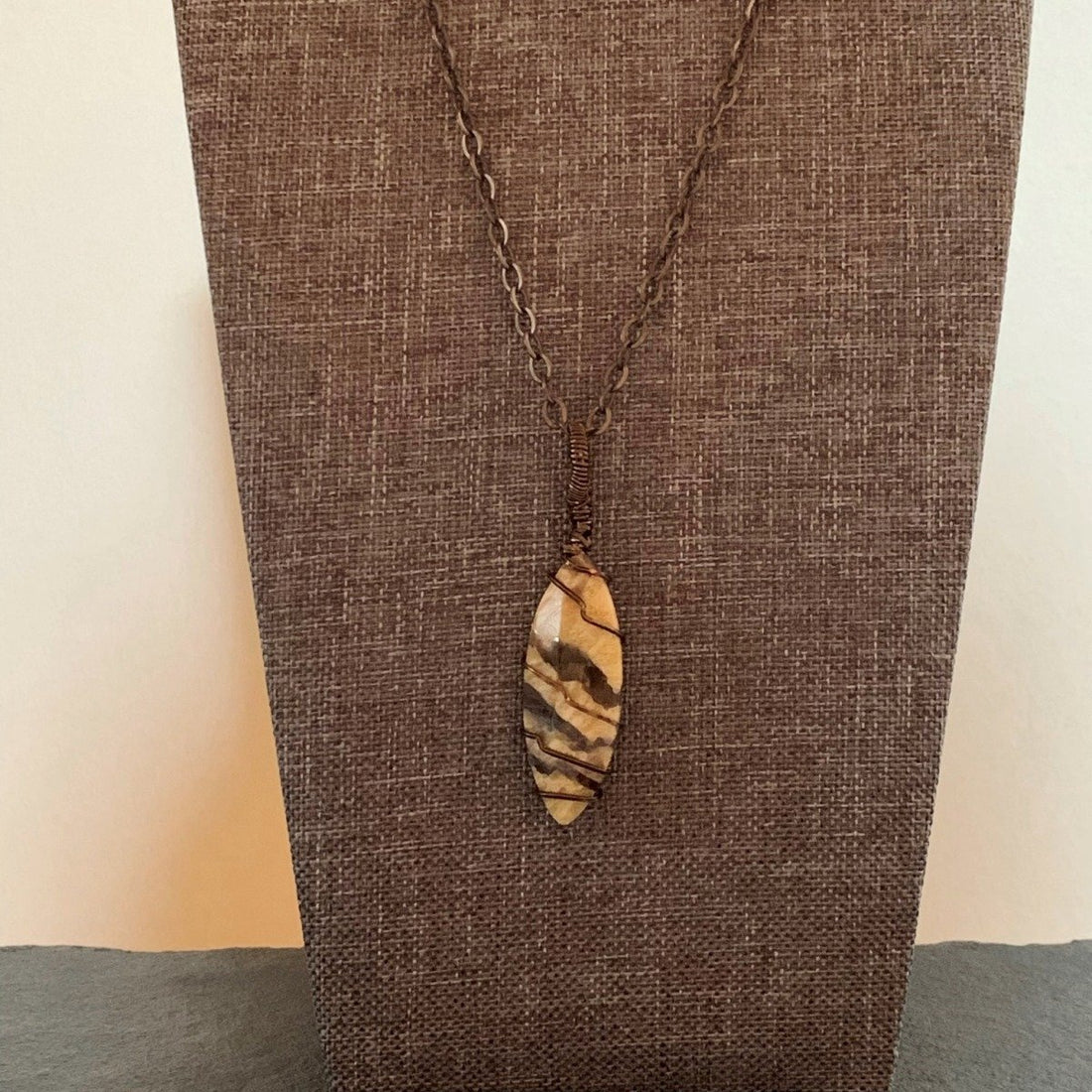 Pendant made of Fancy Jasper vase stone with simple bronze wrap; 5/8" W X 2.5" H INCL BAIL