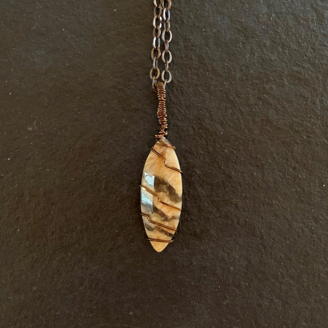 Pendant made of Fancy Jasper vase stone with simple bronze wrap; 5/8" W X 2.5" H INCL BAIL