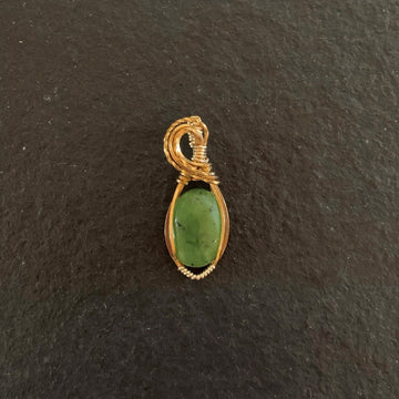 Pendant made of Green Jade oval stone with gold wrap; 5/8" w x 2 3/8" h, incl bail