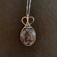 Pendant made of Large Lapis Lazuli in Pyrite Oval with silver wire wrap and crystal accent beads; 1 1/8" w x 2.5" h, incl bail