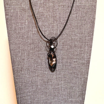 Pendant made of Ivory Copper Obsidian Oval stone, White Magnesite accent cabochon with black wire wrap; .5" w x 1 7/8" long, incl bail; comes with a 18" black cord with 2 " extender