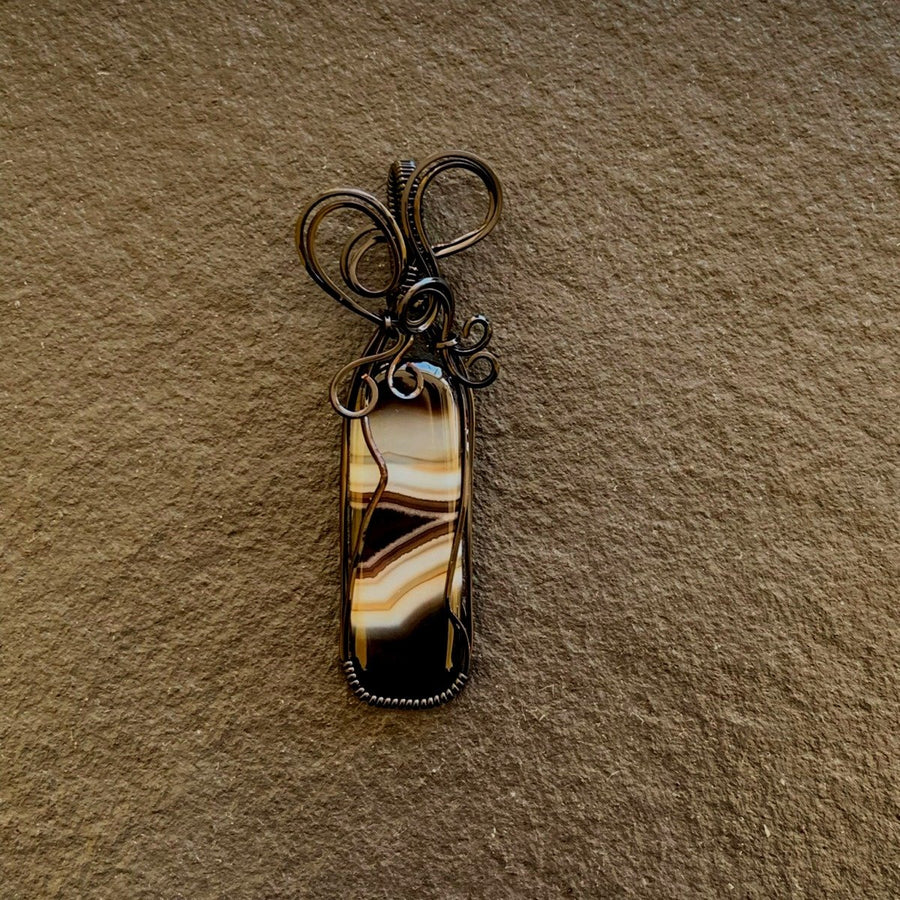 Pendant made of Black & White Banded Agate Rectangle with Black wire wrap; 1" w x 2.5" long