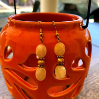 A jewelry set made of matching pineapple quartz with yellow and clear crystals; containing two bracelets and one pair of earrings.