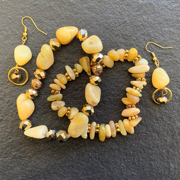 A jewelry set made of matching honey opals with gold rondels and gold beads; containing two bracelets and one pair of earrings